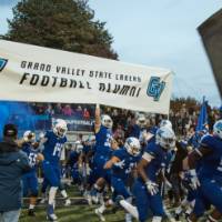 The GVSU Football Team runs onto the field at the start of a game